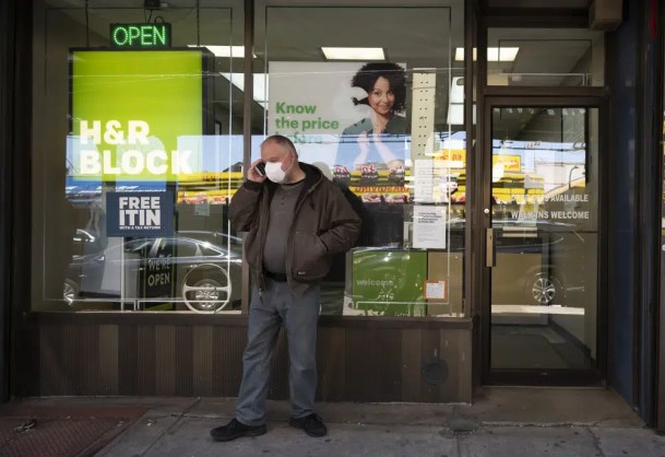 A man waits outside a H&R Block tax preparation office