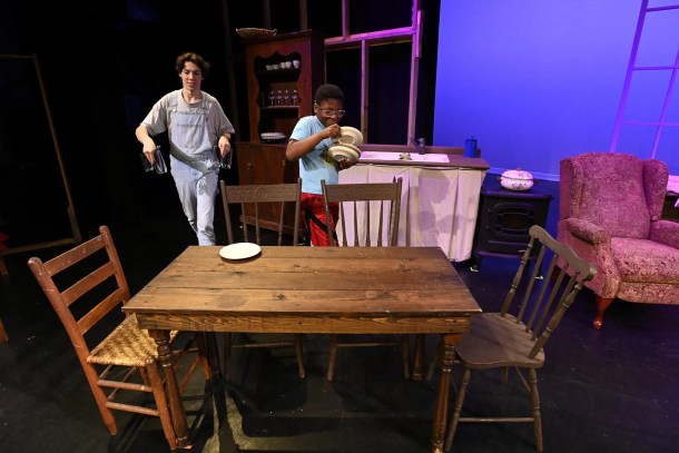 Grayson Hart and cast member Evan Roberts, 11, prepare props on a stage at the Ned R. McWherter West Tennessee Cultural Arts Center in Jackson, Tenn., on Saturday, March 4, 2023. 